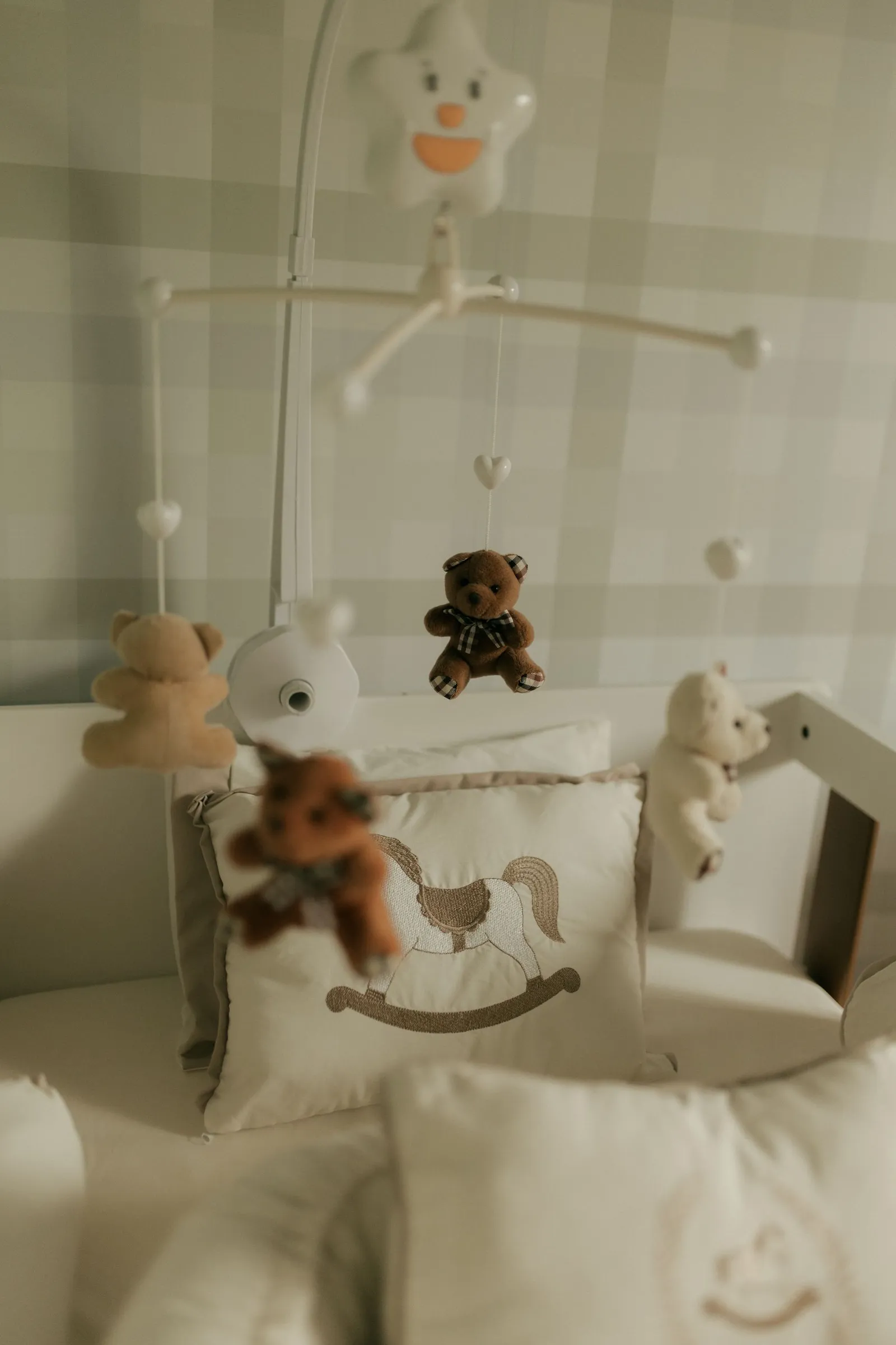 Quarto de bebê tranquilo com móbile de ursinho de pelúcia acima do berço