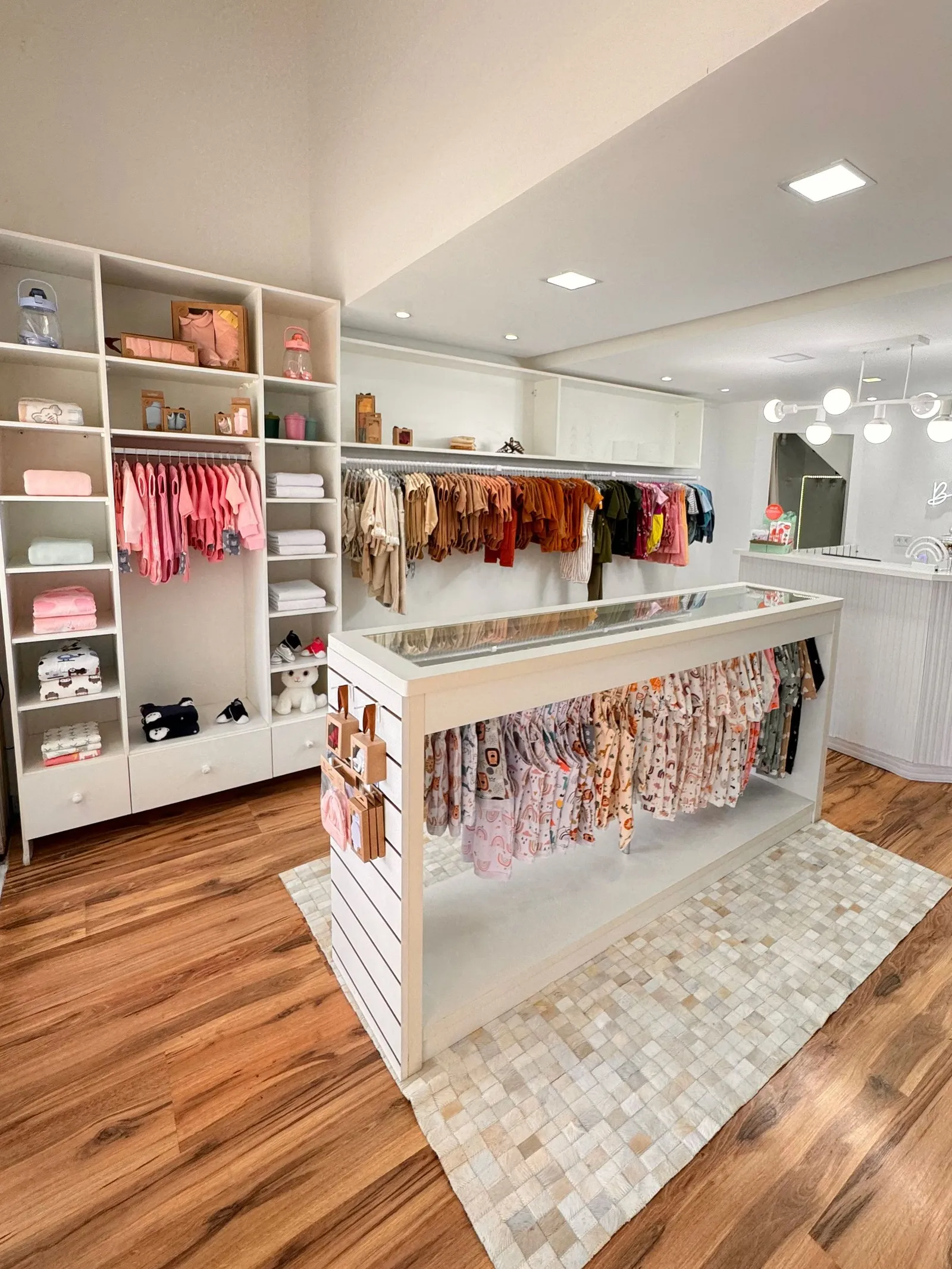 Boutique infantil com roupas de bebê organizadas em araras e prateleiras