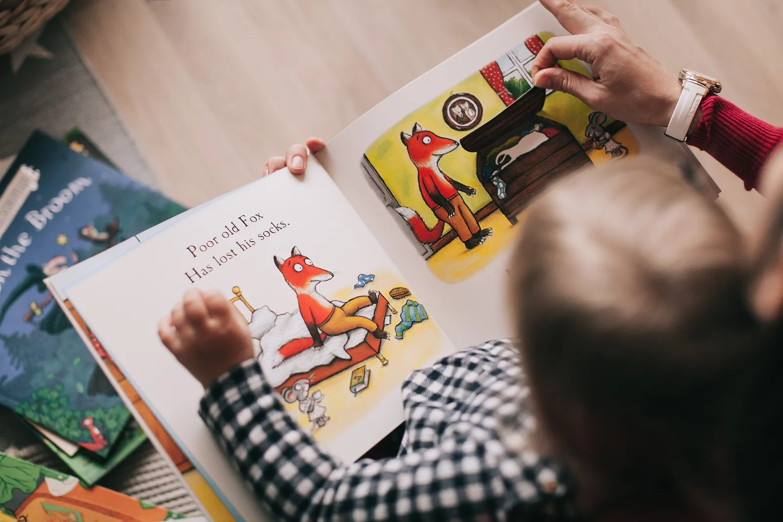 Adulto e criança lendo livro infantil ilustrado juntos em ambiente aconchegante